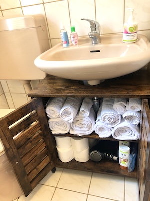 badezimmer-unterschrank handtuecher foehn toilettenpapier shampoo duschgel
