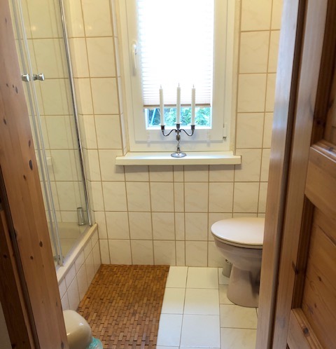 badezimmer, ausstattung, dusche, kleiner muelleimer, fenster, kerzenleuchter, led kerzen, wc, wasserspuelung, fussmatte holz