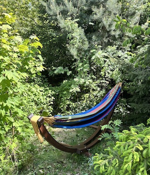 hängematte mit Gestell unter Bäumen im Tiny House Garten in Tanna